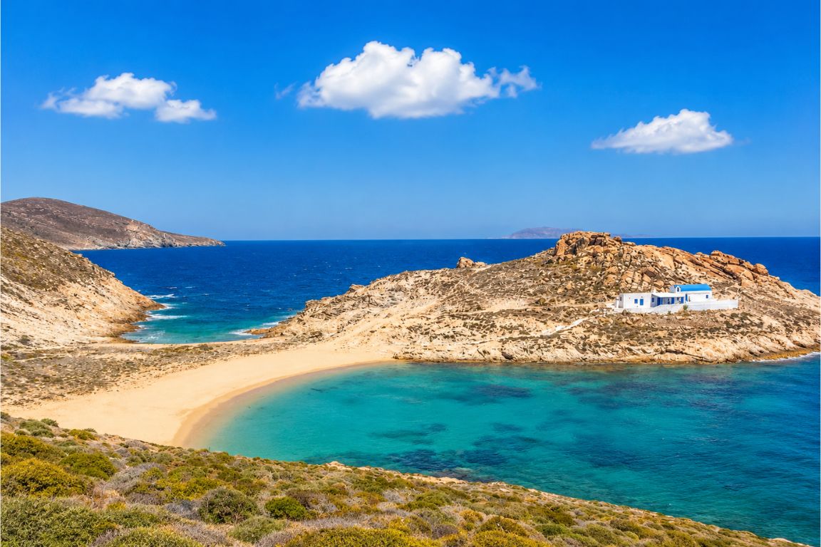 Remote Agios Sostis Beach with vibrant blue water, sandy peninsula, and dramatic coastal scenery enjoyed during a guided tour with Mykonos Tours