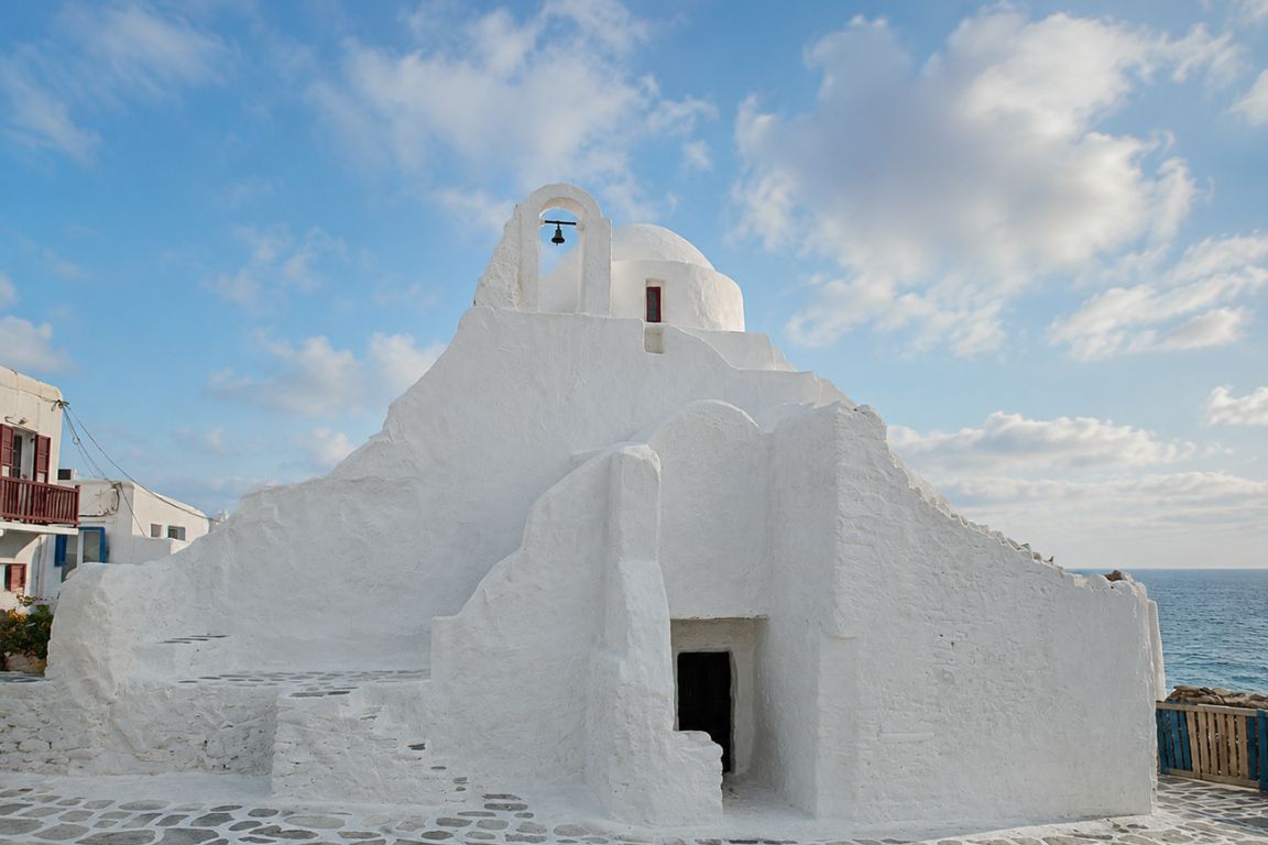 Historic Church of Panagia Paraportiani overlooking the Aegean Sea, explored during a cultural walking tour with Mykonos Tours