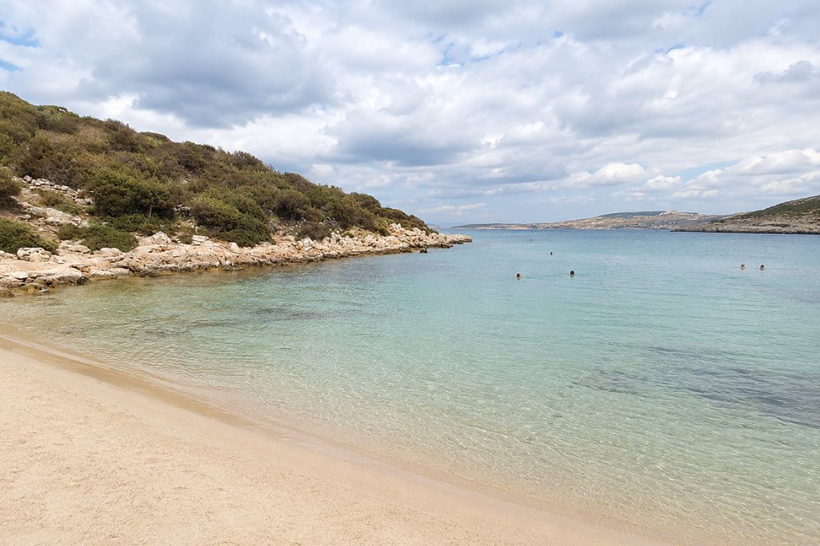 Peaceful view of Platis Gialos Beach with turquoise waters and rocky coastline experienced during a Mykonos Tours adventure